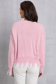 Blush pink knit sweater with distressed hem and cuffs.