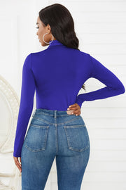 Royal Blue turtleneck thong bodysuit with long sleeves, paired with denim jeans.