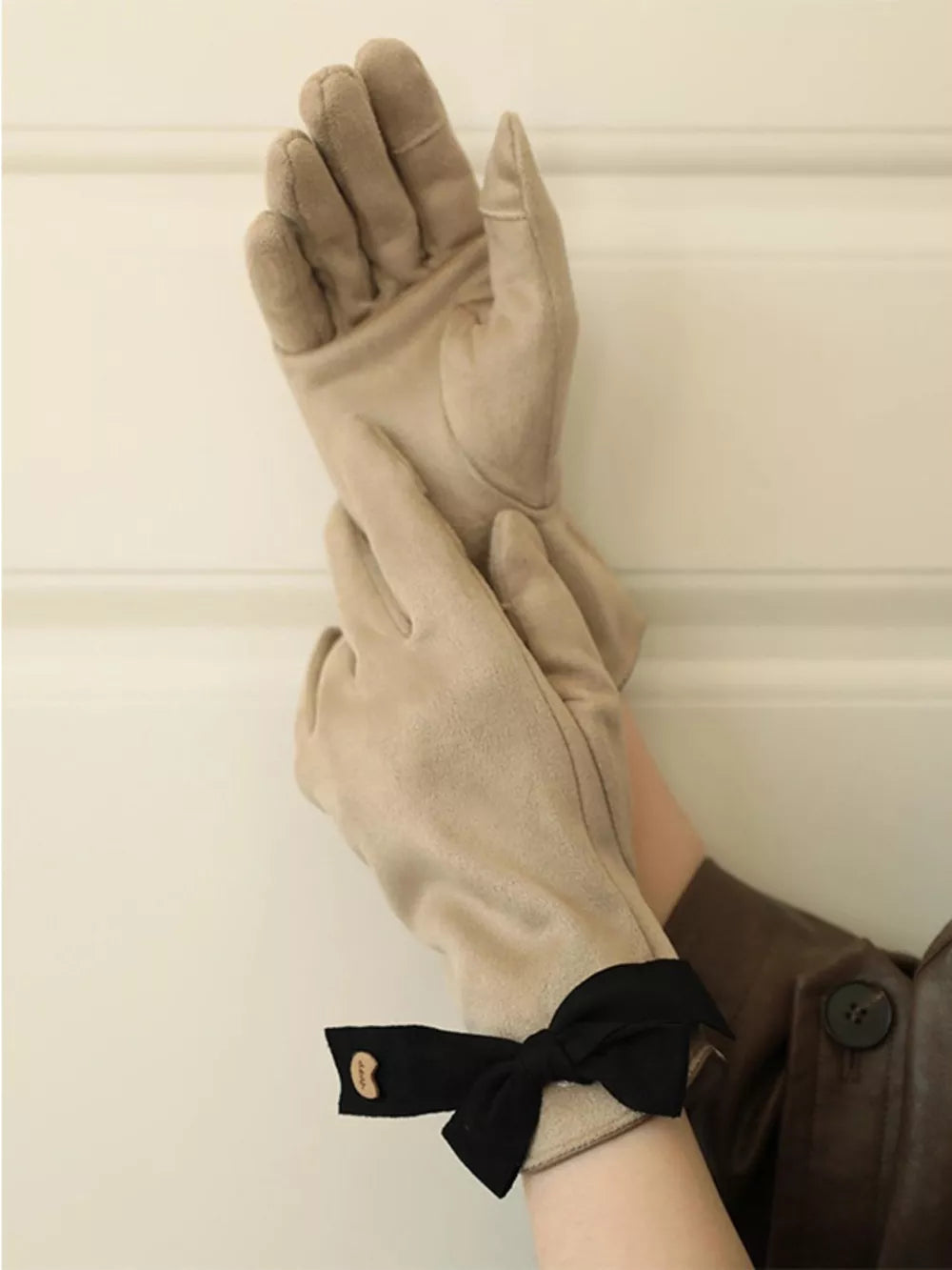 Beige suede gloves with black bow detail on cuff