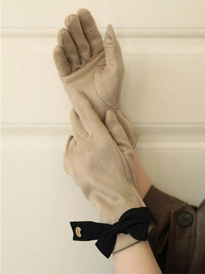 Beige suede gloves with black bow detail on cuff