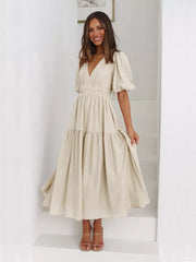 Beige midi dress with puff sleeves, V-neck, and tiered skirt.