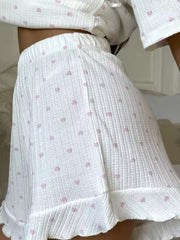 White cotton blend lounge set with pink hearts, ruffled hem shorts and cropped top.