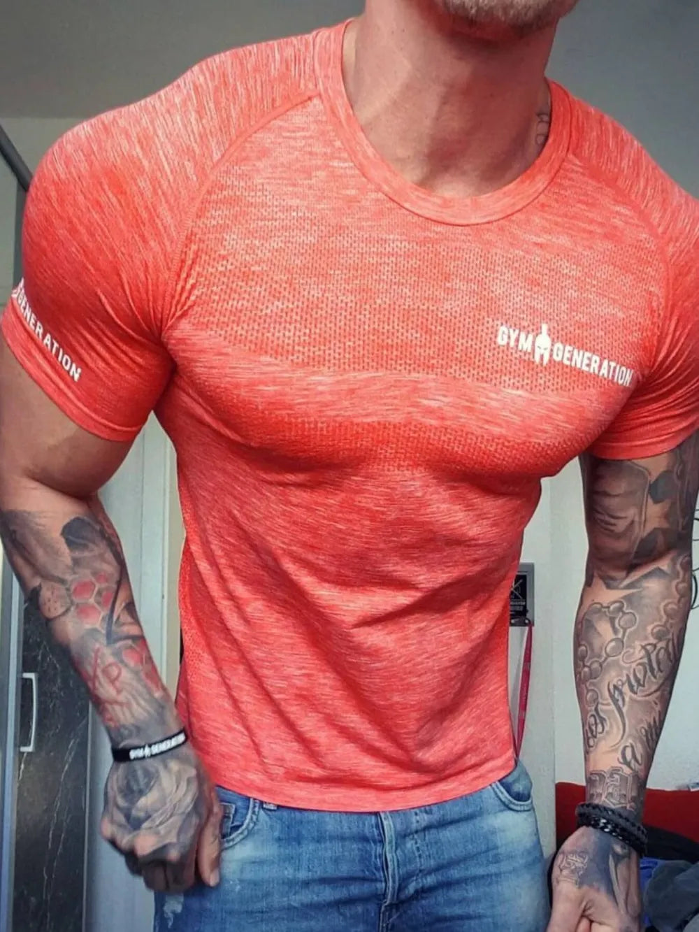 Performance knit gym tee in coral with a crew neck and short sleeves.