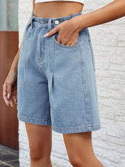 Pleated denim bermuda shorts in light wash with button closure and front pockets.