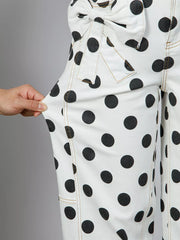 White polka dot high-waisted jeans with bow detail and tan stitching.