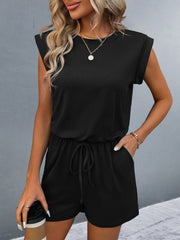 Black shoulder pad romper with drawstring waist and cuffed sleeves.