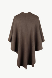Taupe knit cape with ribbed texture and a draped silhouette, detailed with a subtle seam down the back.