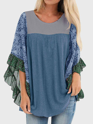 Textured panel blouse in dusty blue with floral print flutter sleeves and green ruffle trim.