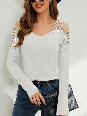 White ribbed knit blouse with strappy cold shoulder cutouts and sequin embellishments.