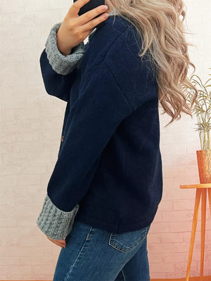 Navy knit cardigan with textured grey cuffs and collar detail.