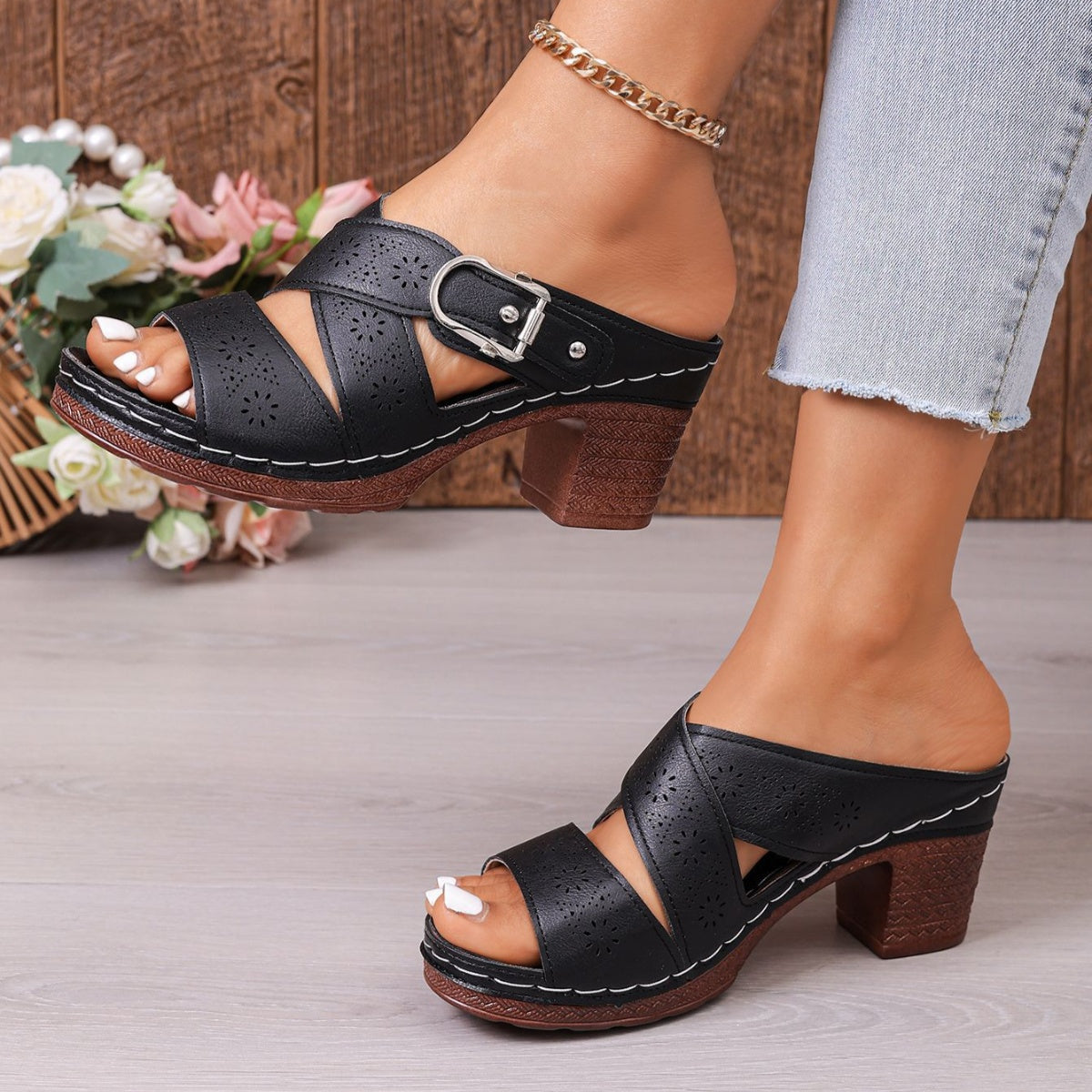 Black laser-cut criss-cross block heel sandals with buckle detail.