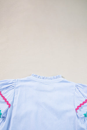 Light blue and white striped blouse with ruffled neckline and scalloped trim sleeves.