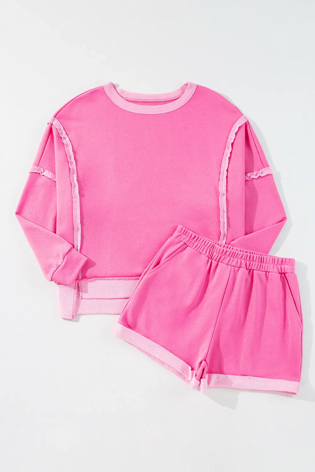 Fuchsia pink cotton loungewear set with contrast trim on crewneck sweatshirt and shorts.