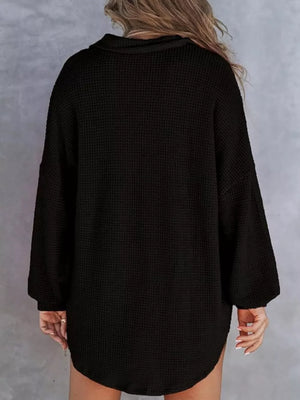 Black waffle-knit henley tee with pocket, long sleeves, and a rounded hem.