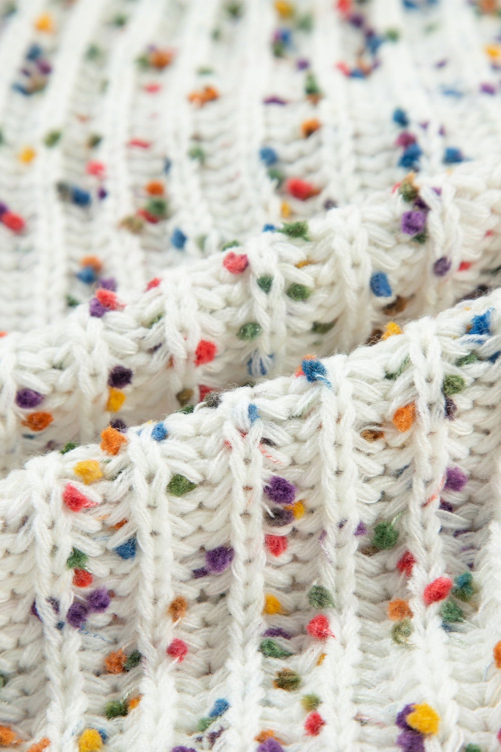 White confetti knit sweater with a textured ribbed pattern and colorful flecks.