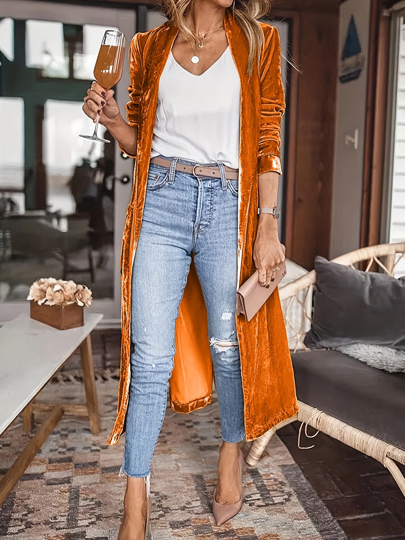 Tangerine velvet duster coat with fluid silhouette, open front, long sleeves, worn with jeans.