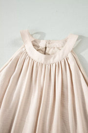 Beige halter maxi dress with gathered neckline and airy fabric.