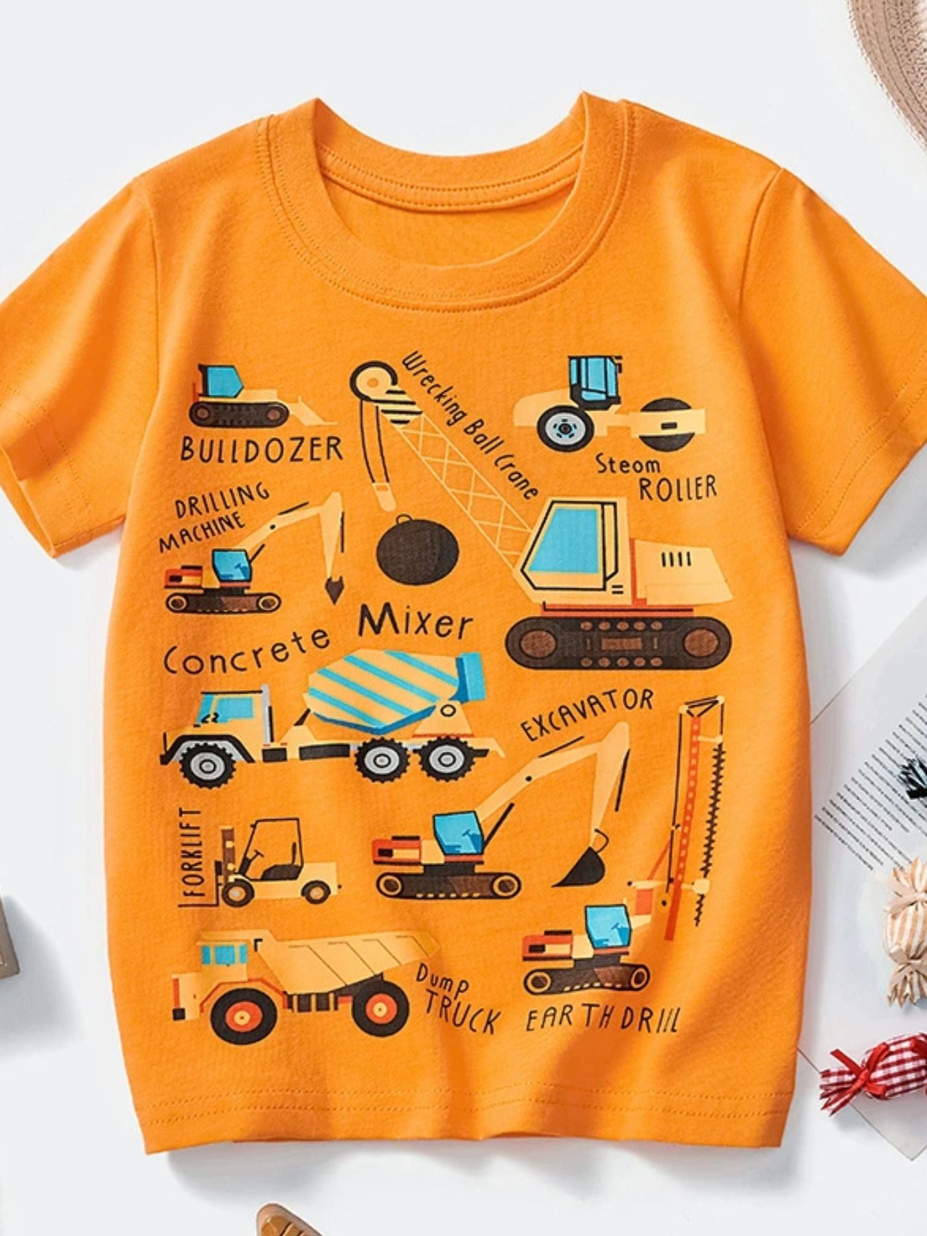 Orange cotton crew neck t-shirt with a playful construction vehicle print for kids.