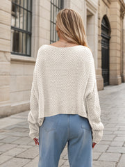 White acrylic cable knit cocoon sweater with wide neckline and cropped hem.