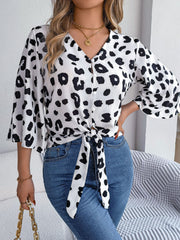 Leopard print tie-front blouse with button detail and flared sleeves.