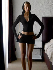 Black cropped zip-up hoodie and ruched shorts set with a deep V-neck and long sleeves.