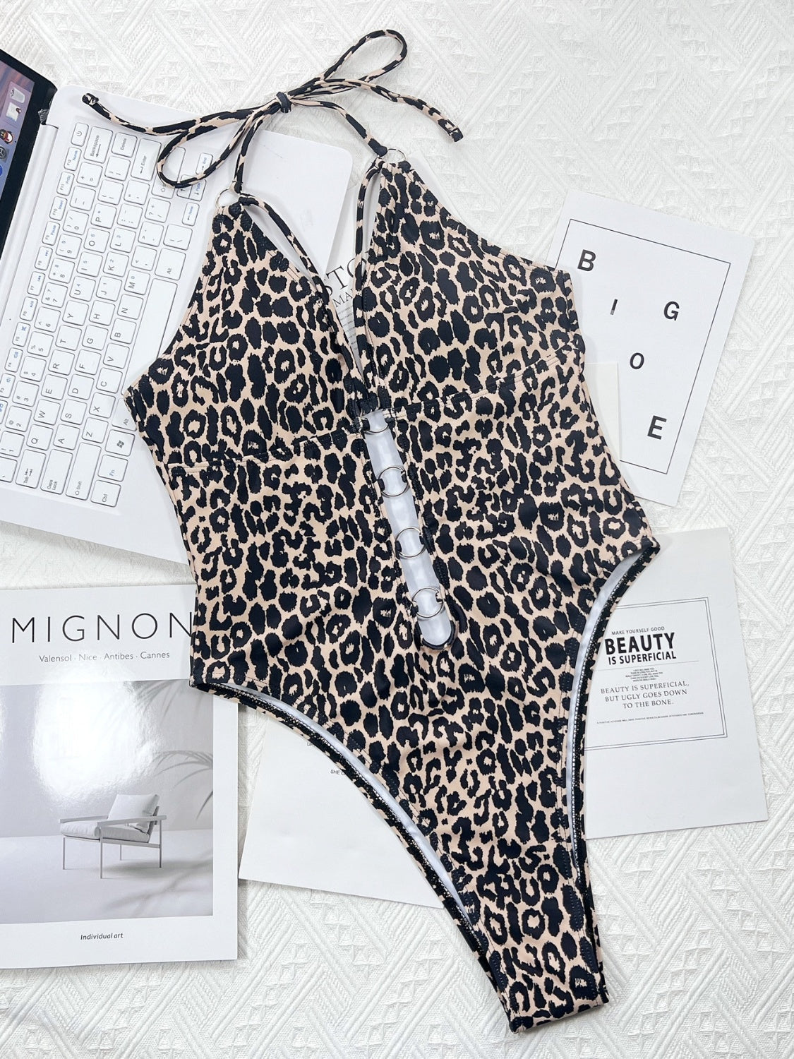 Leopard print one-piece swimsuit with ring detail and halter neck.