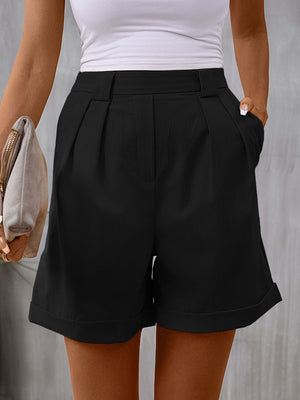 Black pleated tailored bermuda shorts with cuffed hems and a cinched waist.