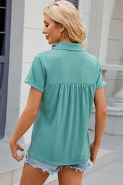 Turquoise polo top with short sleeves and gathered yoke detail.