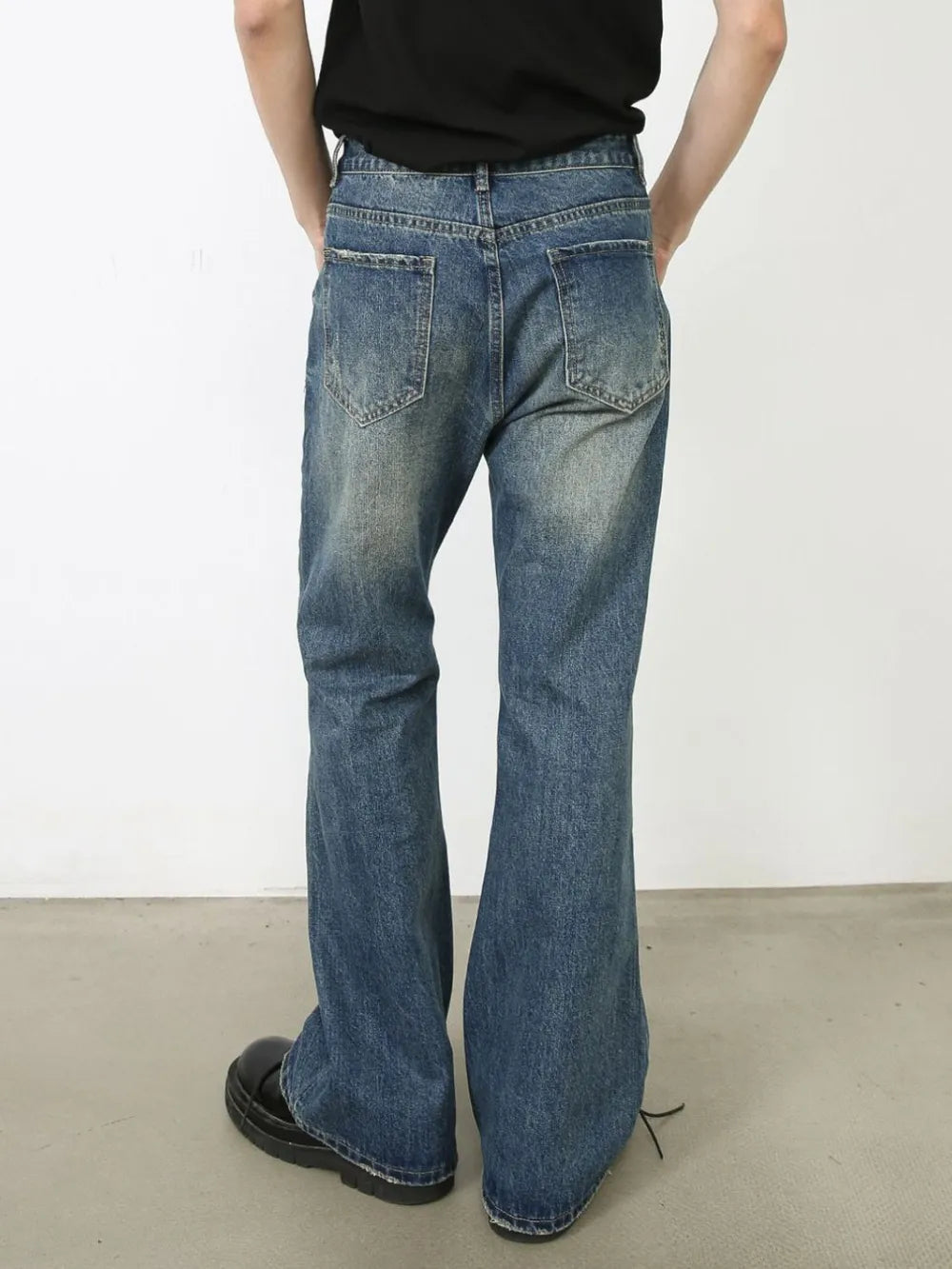 Distressed flare leg jeans in medium wash denim with a buttoned fly and casual styling.