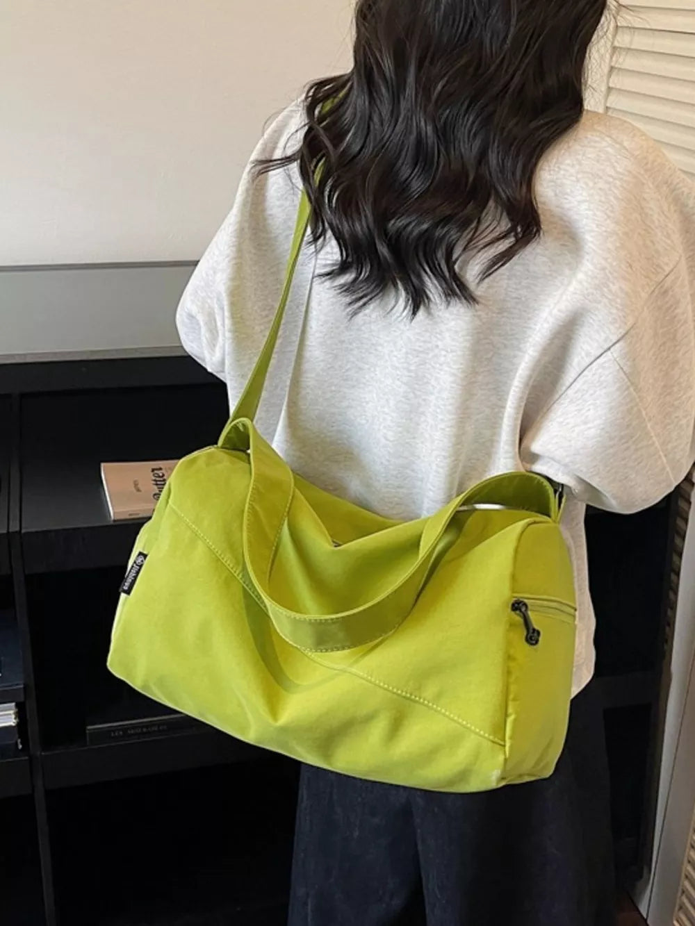 Green Oxford cloth travel bag with adjustable strap and zippered pocket.