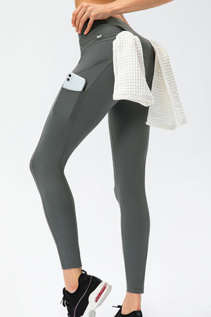 Dark Gray athletic leggings with utility pockets and a white towel draped over the hip.