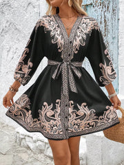 Black paisley mini dress with V-neck, billowy sleeves, and waist tie