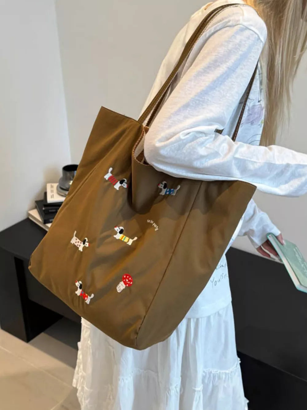 Brown shoulder bag with charming dachshund embroidery and mushroom detail.