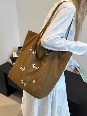 Brown shoulder bag with charming dachshund embroidery and mushroom detail.