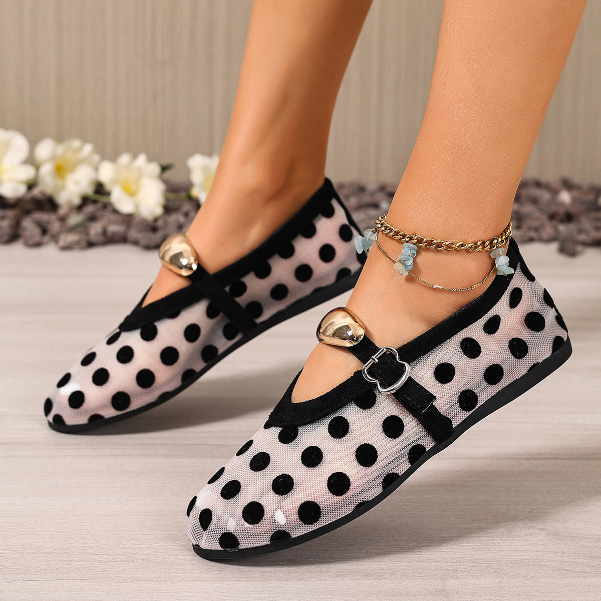 Black polka dot mesh slip-on flats with gold heart detail and ankle strap.