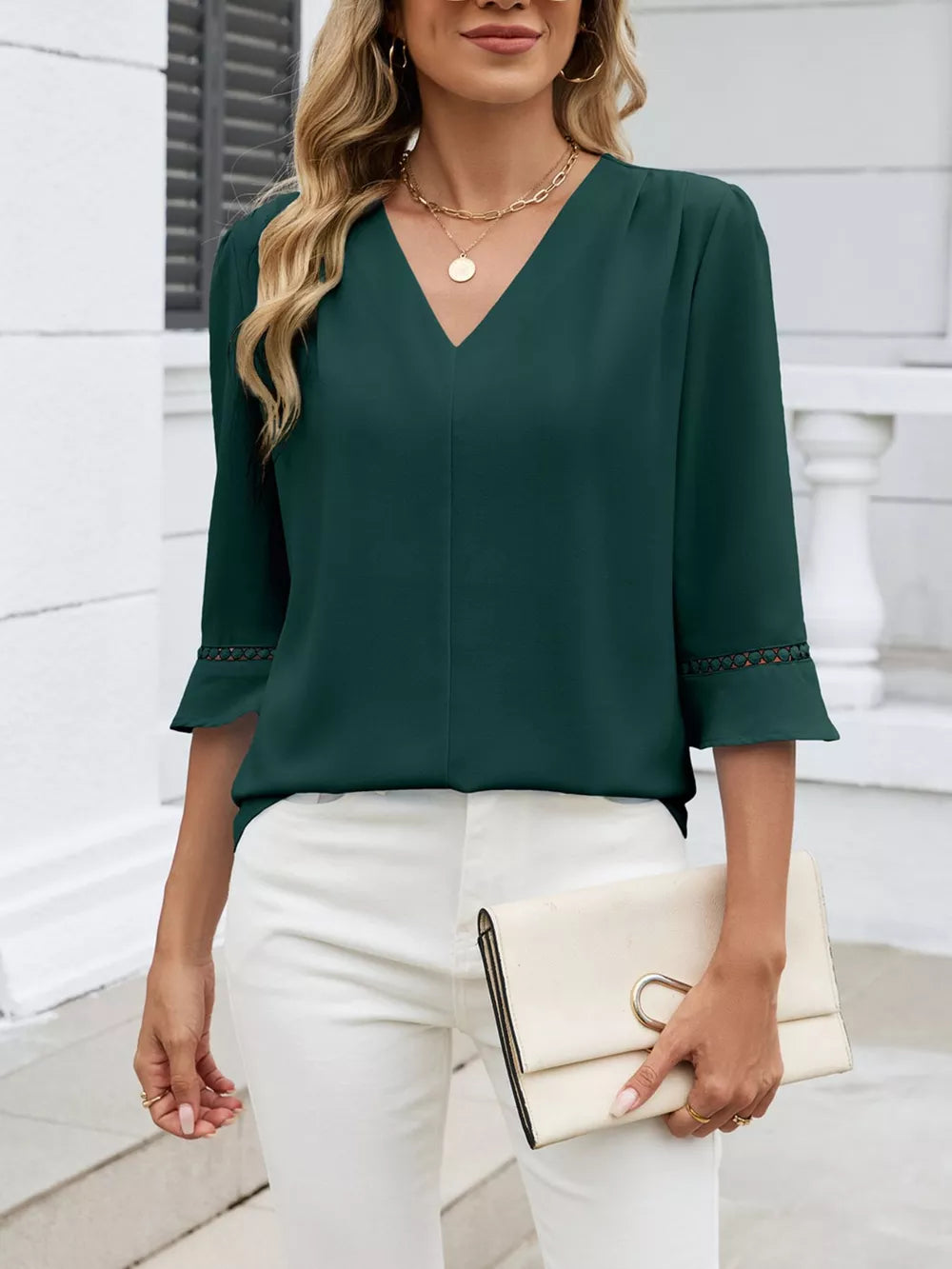 Dark green V-neck blouse with 3/4 sleeves featuring lace trim at the cuffs.