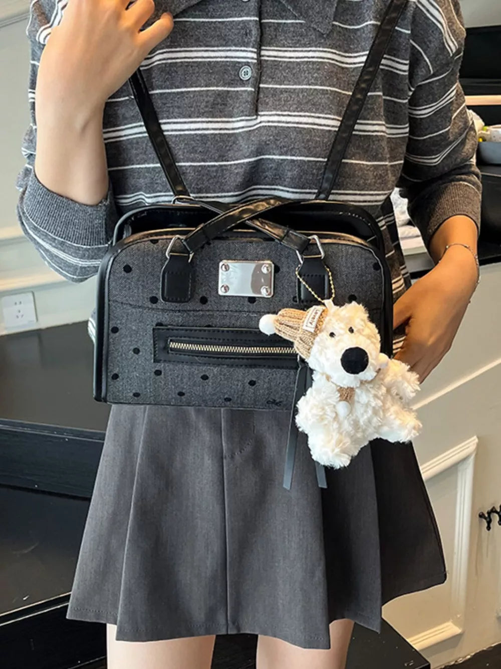 Sophisticated black polka dot shoulder bag with a plush teddy bear charm.