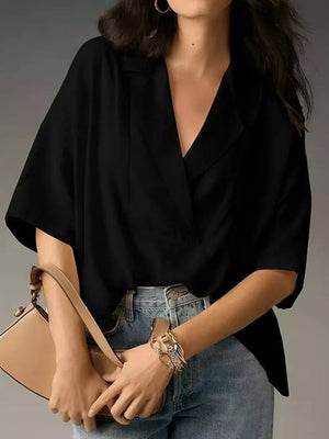 Black V-neck half sleeve shirt with a relaxed fit, styled with jeans and a handbag.