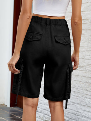 Black denim cargo bermuda shorts with buttoned flap pockets and drawstring hem.