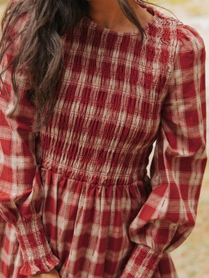 Red and cream plaid cotton mini dress with smocked bodice and puff sleeves.