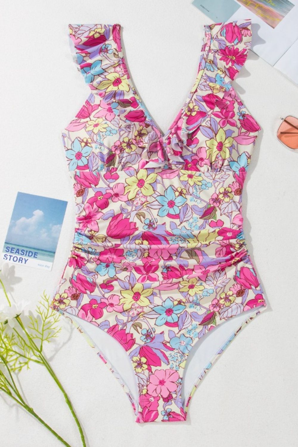 Floral ruffle one-piece swimsuit in fuchsia pink with ruched sides and a V-neck.