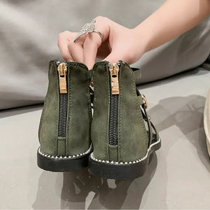 Army green gladiator sandals with gold zip-back detail and decorative studs.