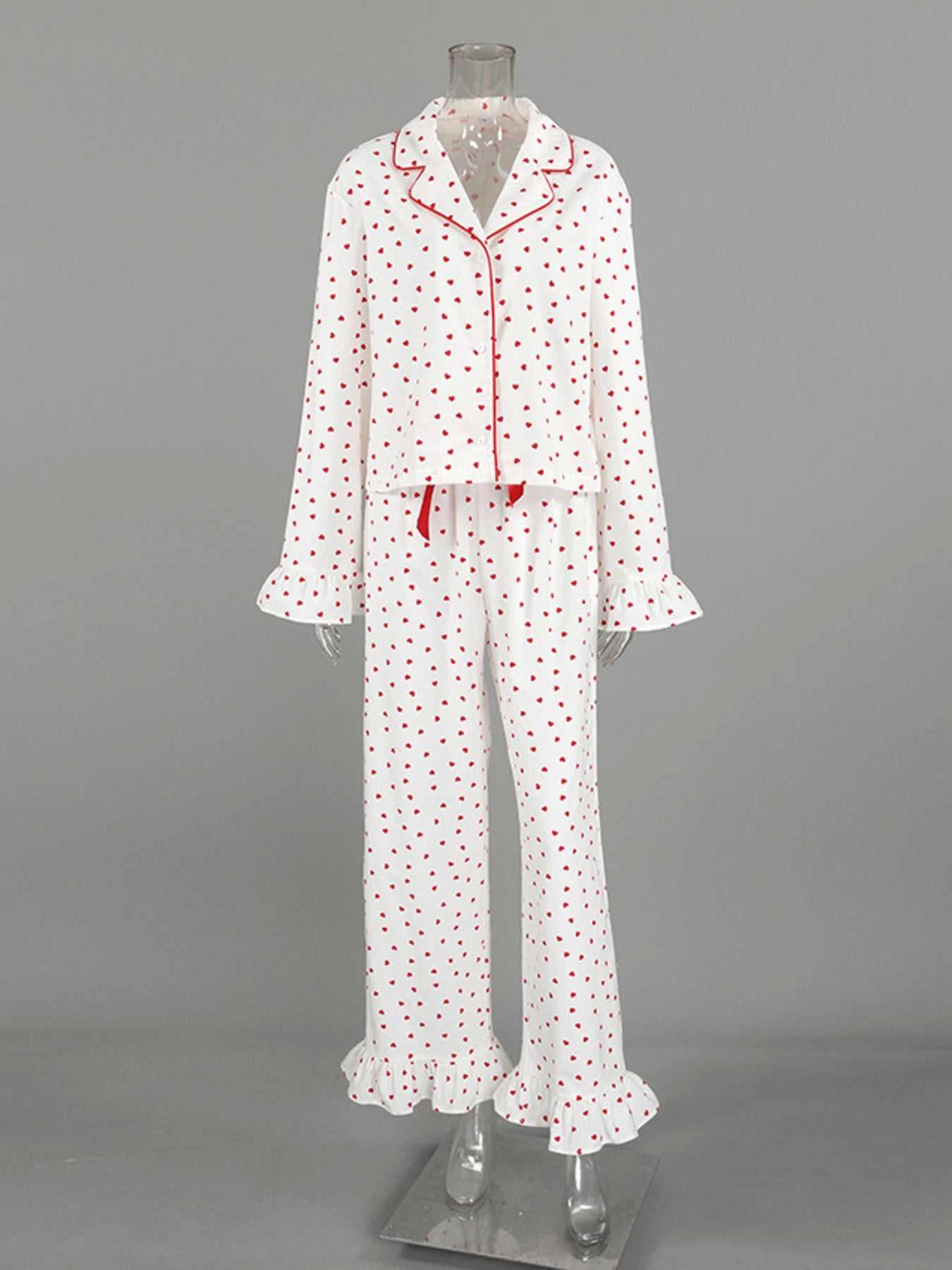 White cotton pajama set with red heart pattern, button front top, and ruffled cuffs and hem.
