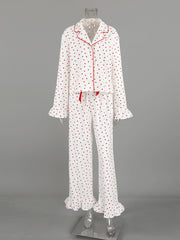 White cotton pajama set with red heart pattern, button front top, and ruffled cuffs and hem.