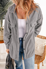 Fleece shirt jacket in charcoal with patch pockets and button front.