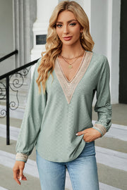 Light green textured V-neck blouse with lace trim on neckline and cuffs.