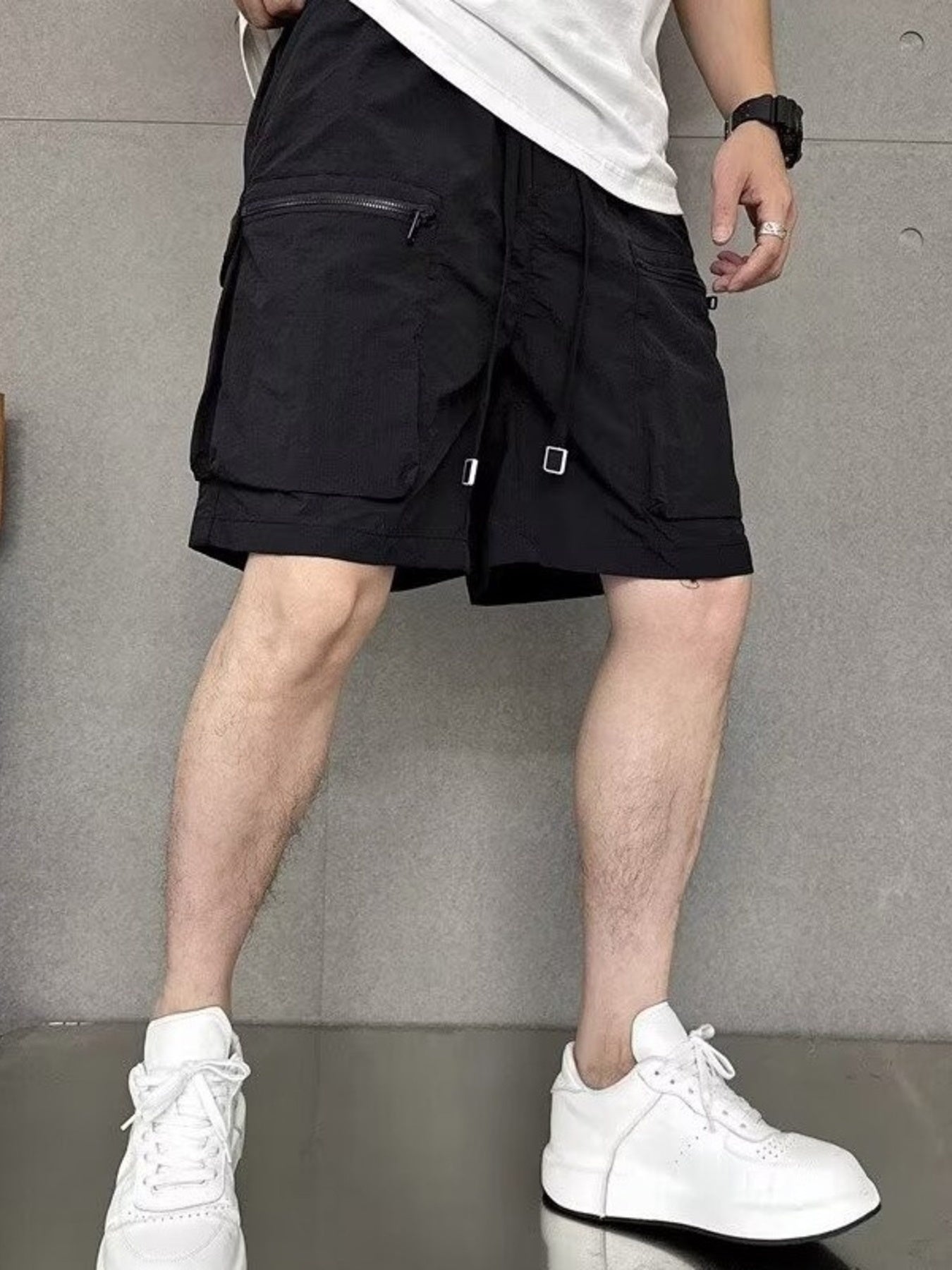 Men's black lightweight multi-pocket cargo shorts with adjustable drawstring and zippered pockets.