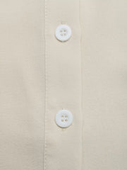 Beige button-down maternity overshirt with white buttons and subtle texture.