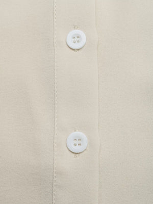 Beige button-down maternity overshirt with white buttons and subtle texture.