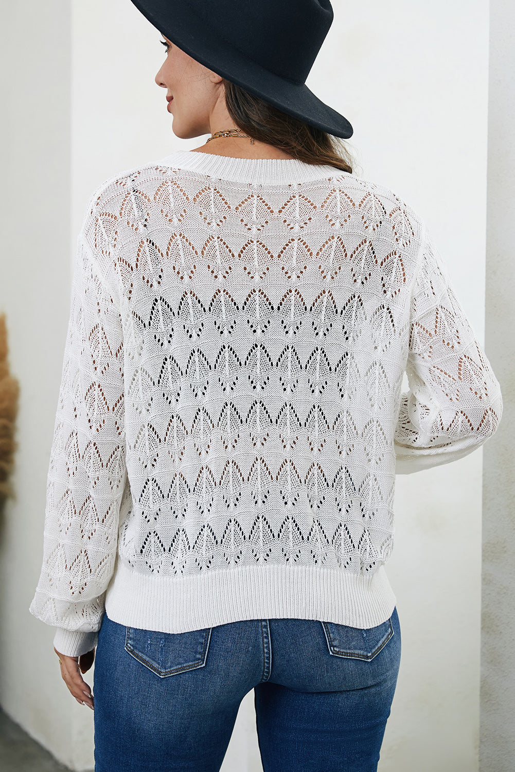 White openwork knit cardigan with balloon sleeves and diamond pattern.